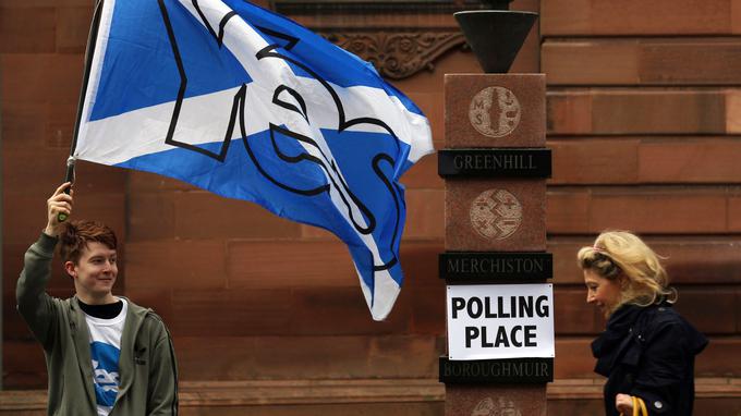 Un partisan de l'indépendance de l'Écosse agite le drapeau écossais orné d'un «oui», le 18 septembre 2014, jour du référendum sur l'indépendance écossaise.